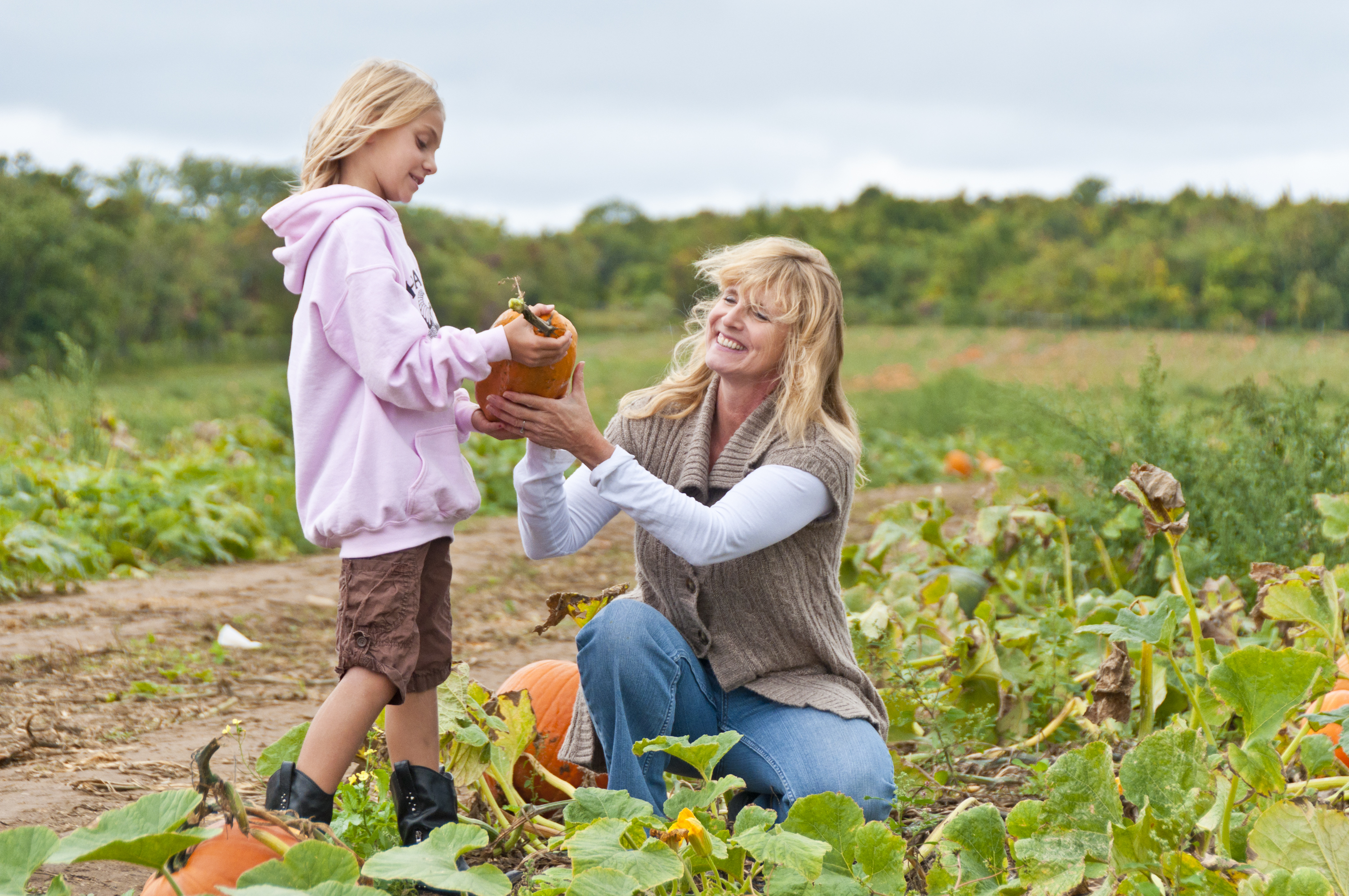 Monica Harbes picking pumpkins with her grand daughter